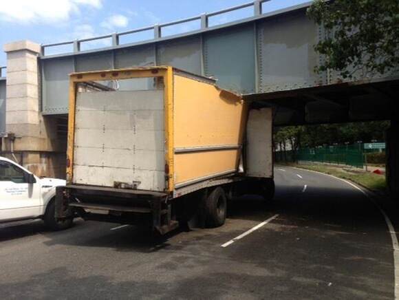 rental truck getting stuck under a low bridge