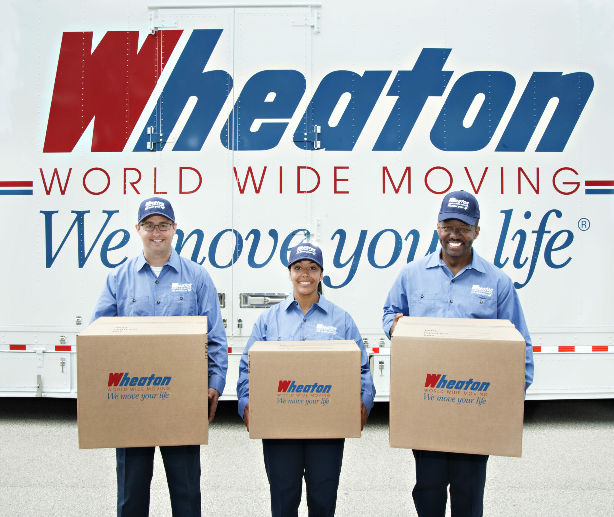 Wheaton World Wide Moving crew holding boxes in front of a moving truck