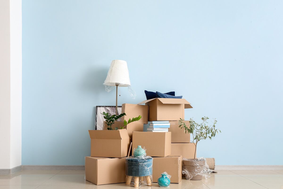 Cardboard boxes with belongings in new flat on moving day