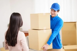 asian man moving boxes in front of the owner
