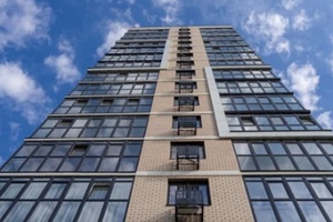 bottom view of tall apartment building facade
