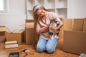 happy modern ginger woman with braids moving into new home with her pet