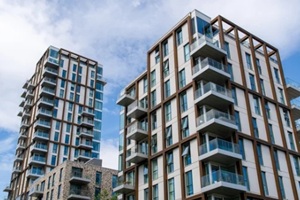 modern residential apartment buildings with balconies under blue sky in urban setting