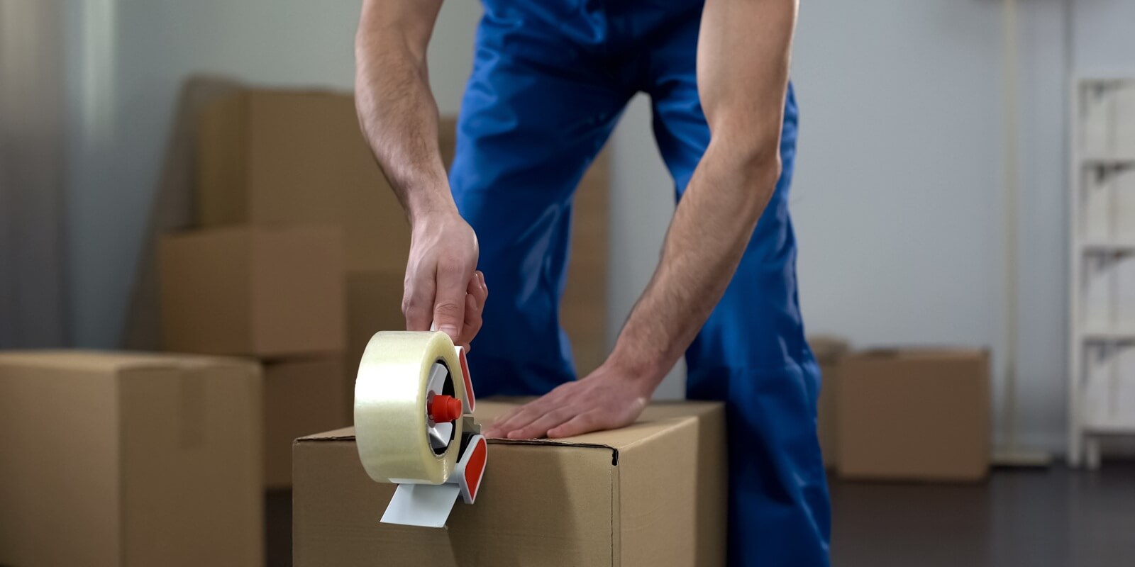 moving company worker packing cardboard boxes