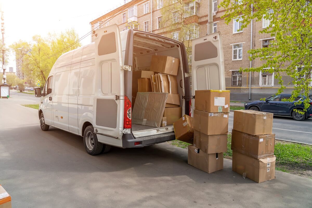 open lorry car trunk with moving cardboard packages outdoors