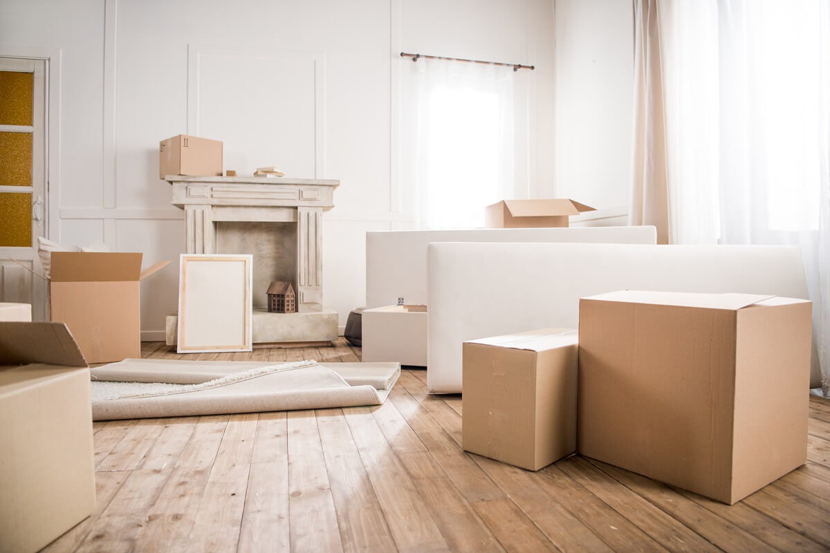 picture frame and cardboard boxes in empty room relocation concept