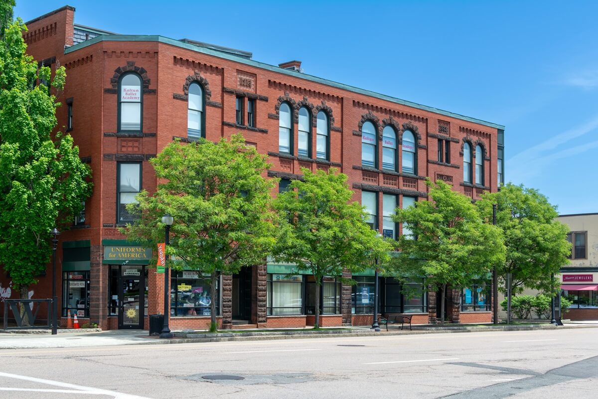 street view of a historic red brick building with shops of Watertown Massachusetts