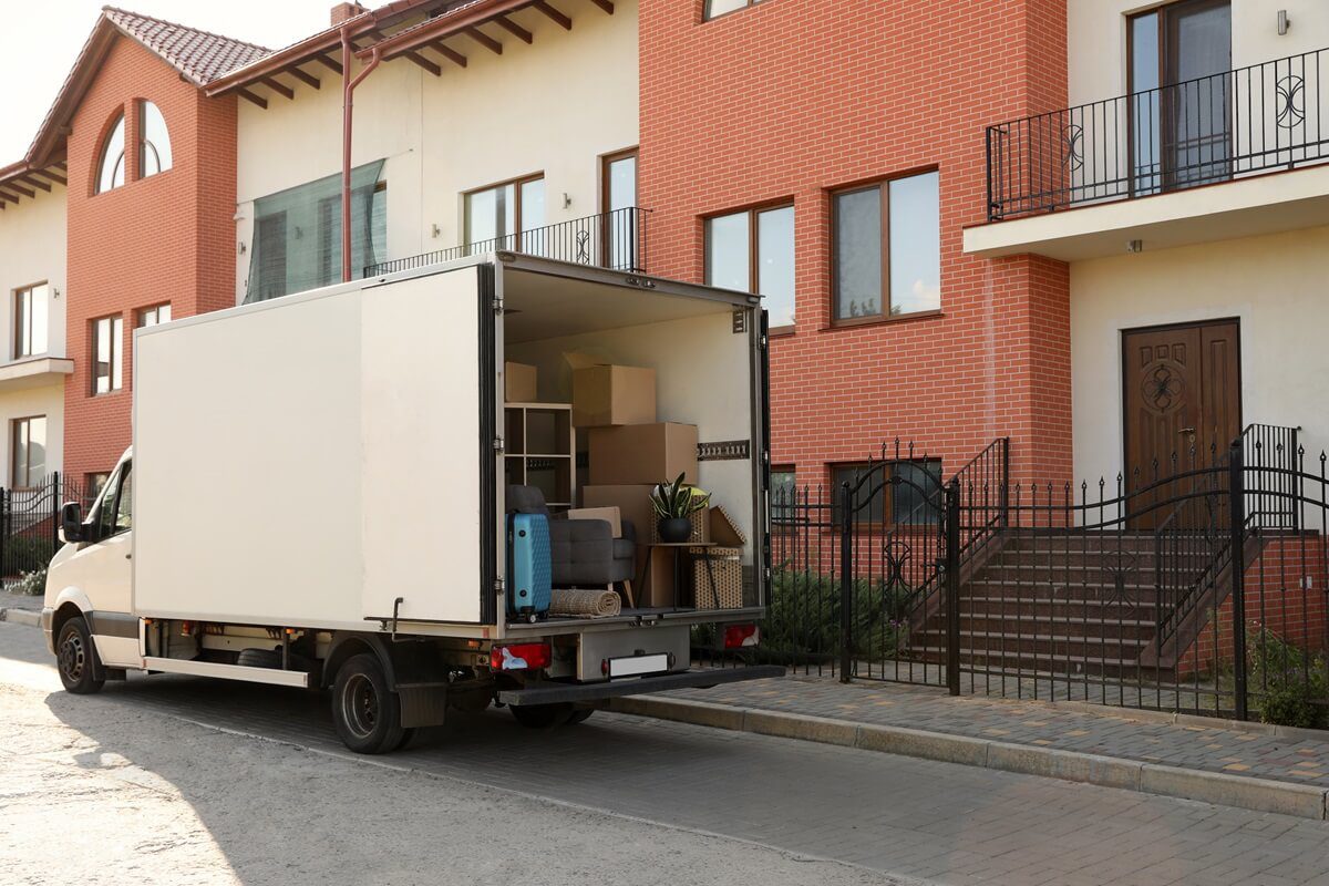 van full of moving boxes and furniture near house