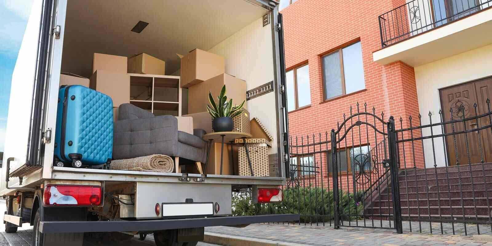 van full of moving boxes and furniture near house